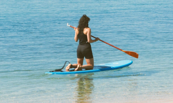 Rapariga a remar em cima da prancha de SUP (standup paddleboarding) no Rio Mira, em Vila Nova de Milfontes. Atividade combinada de SUP com SUP Yoga - Deep Silence River Tour